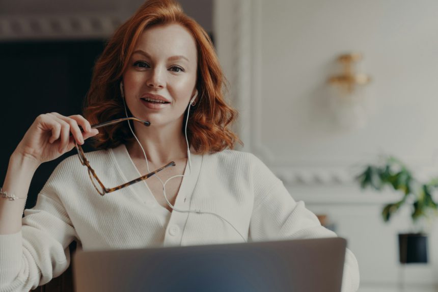 Successful redhead woman entrepreneur ready to conduct online negotiations with coworkers